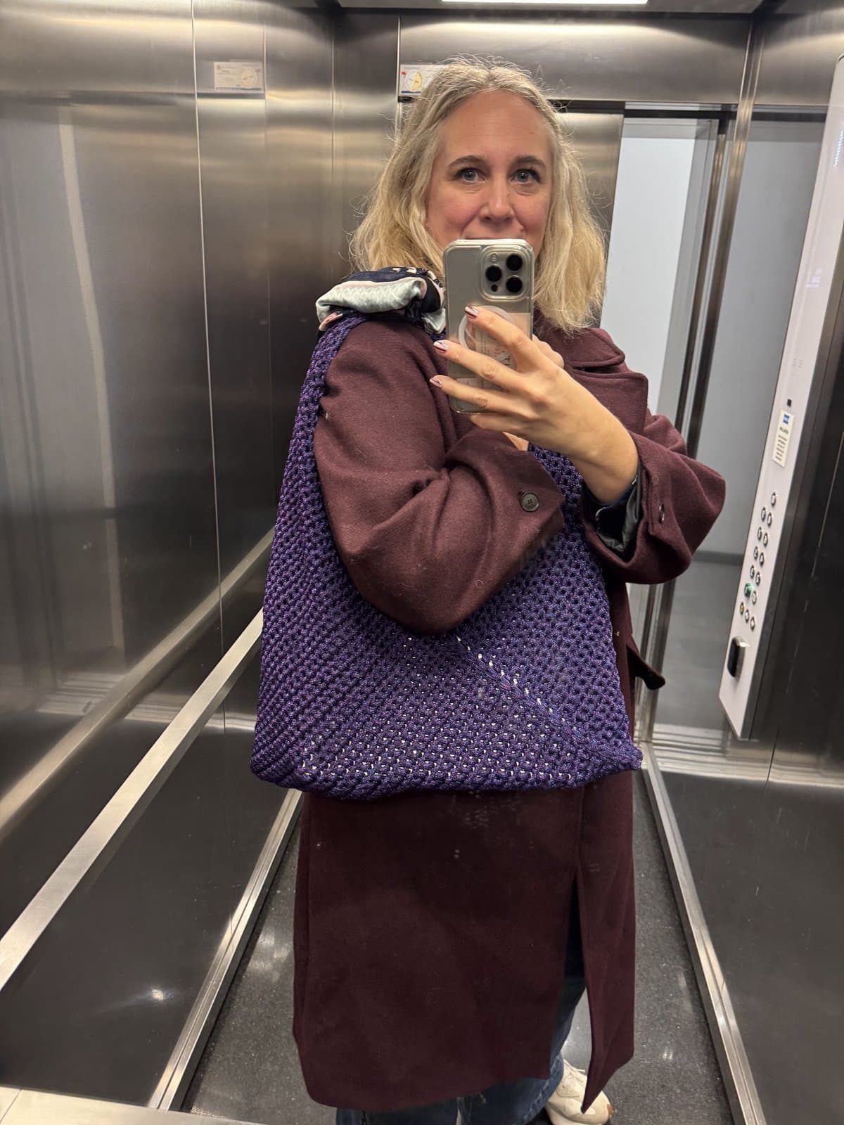 Silje med vesken på skulderen i en heis