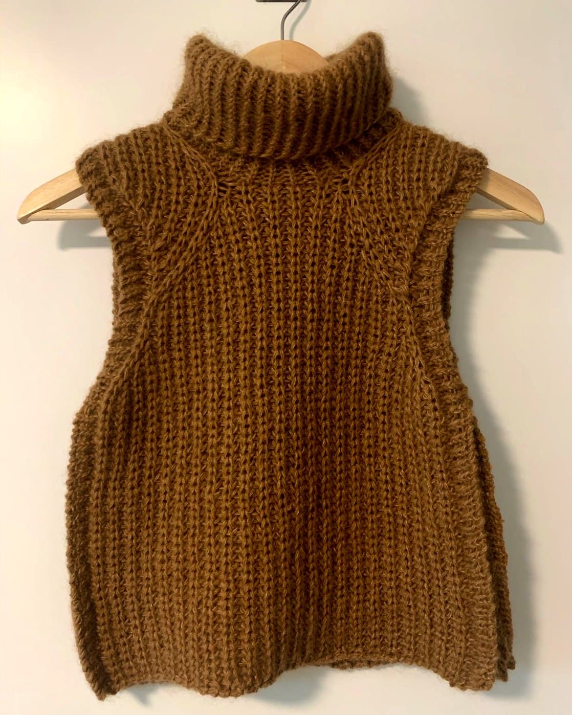 Brun vest med høy hals i halvpatent på kleshenger